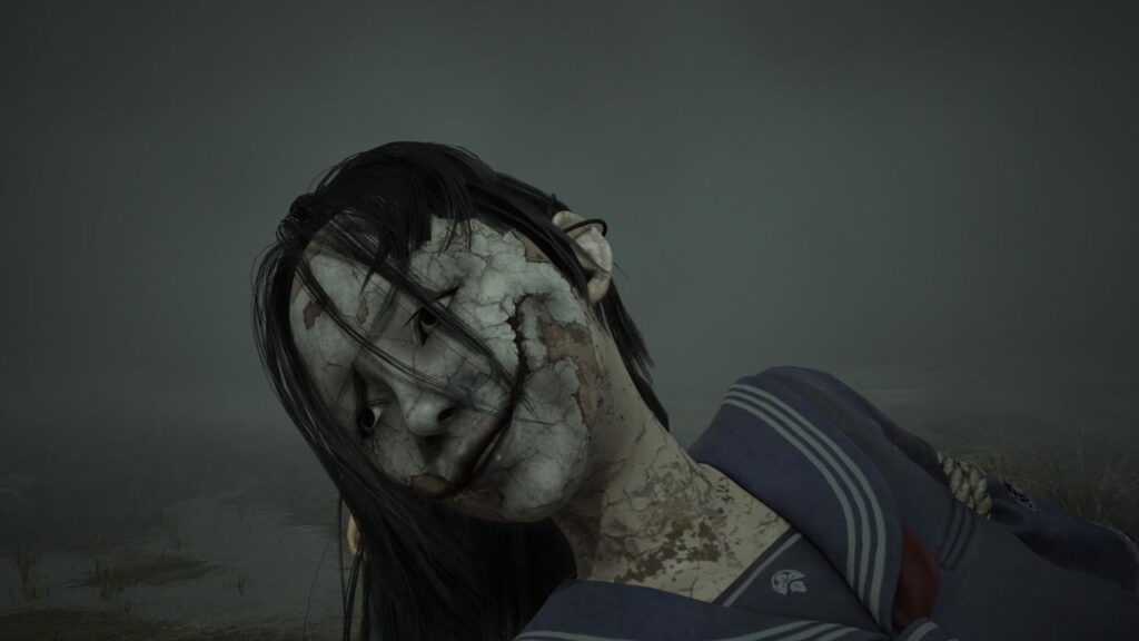 Rozbitá bábková hlava školáčky s prasklinami a úsmevom v Silent Hill F