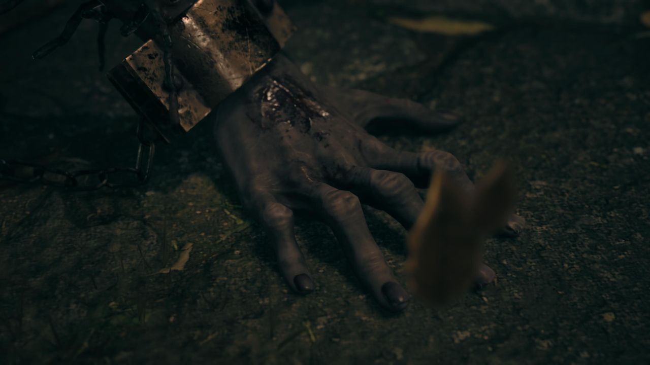 Zakrvanená ruka so železnou manžetou a reťazou na zemi — Silent Hill F.